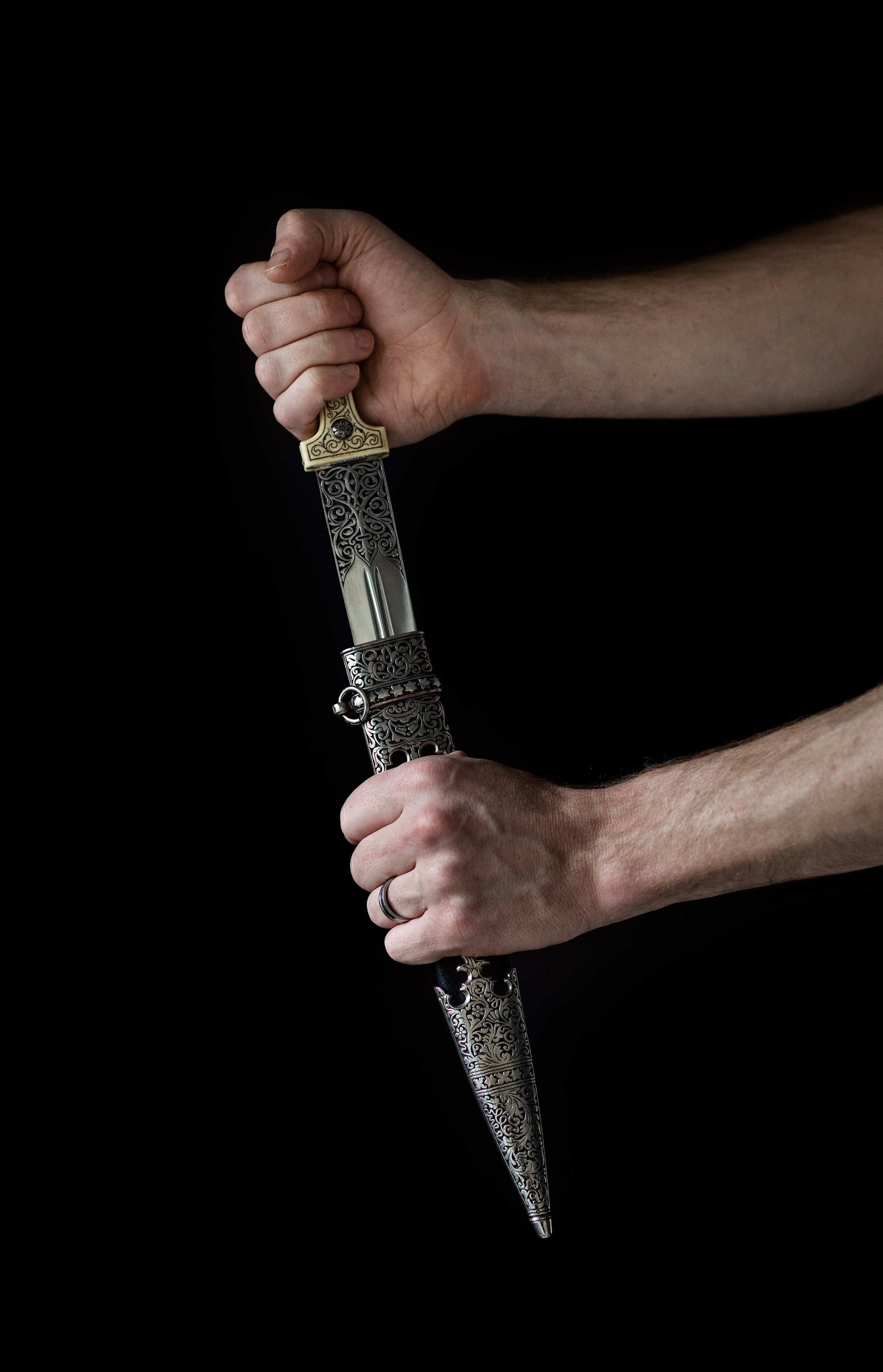 a-hand-draws-an-ornate-dagger-from-its-sheath.jpg